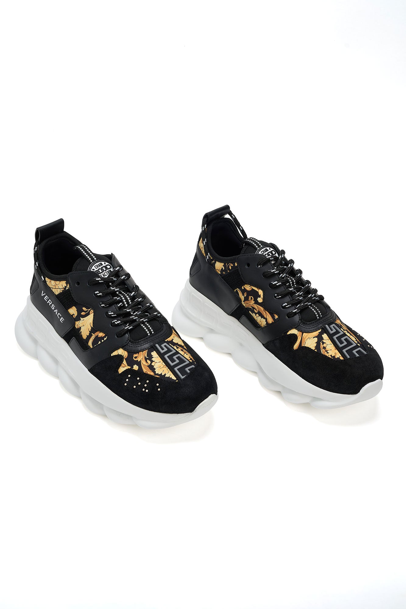 Black Versace sneakers with gold designs on a white background