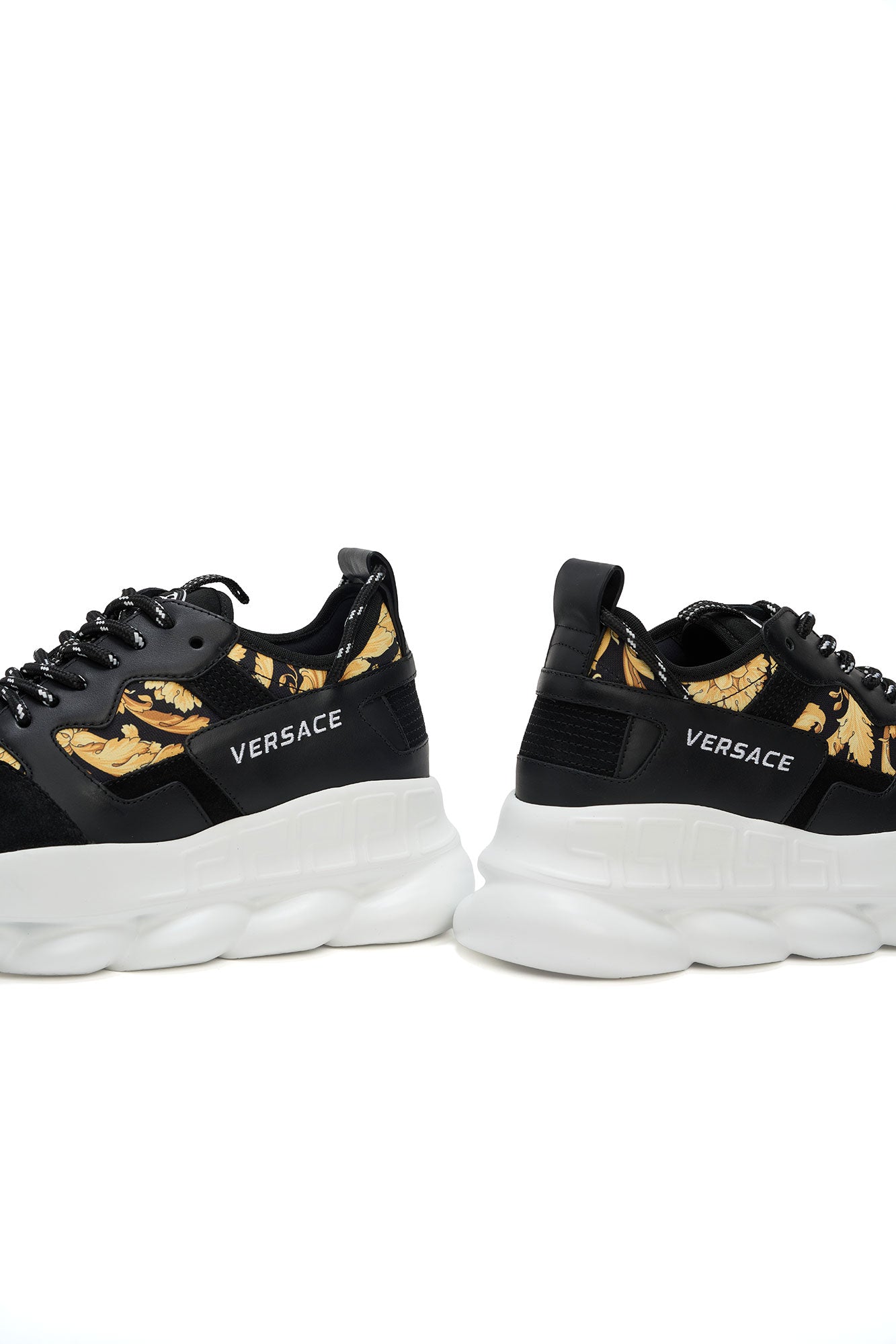 Black Versace sneakers with gold accents on a white background