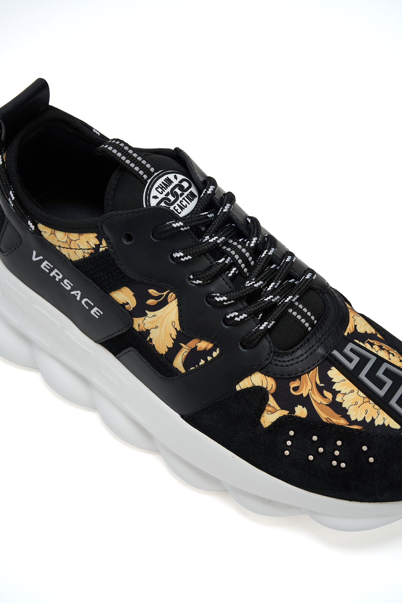 Black Versace sneaker with gold patterns on a white background