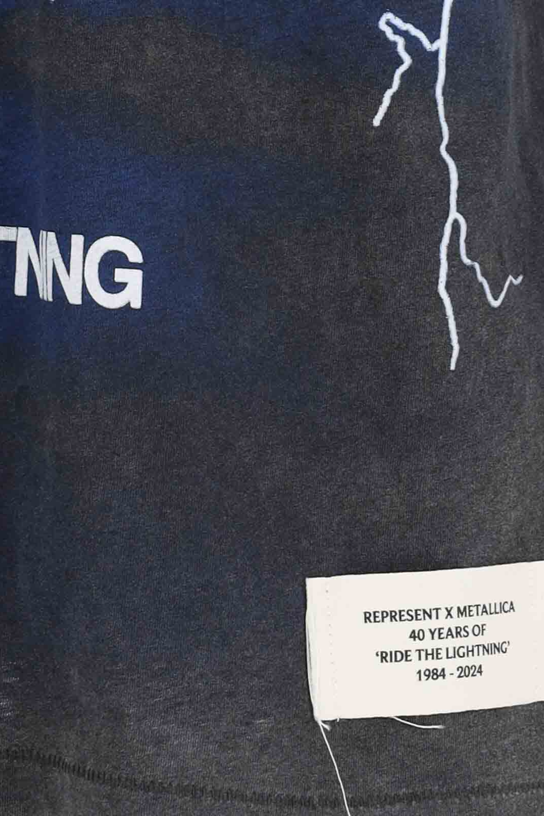 Black t-shirt with 'REPRESENT X METALLICA' label and lightning bolt design on a dark background